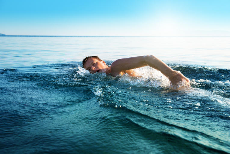 man swimming in ocean